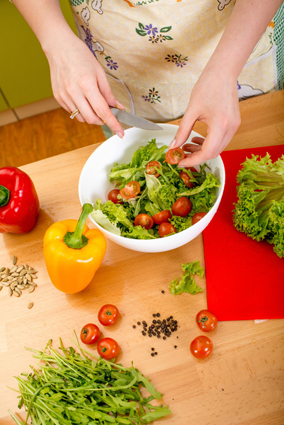 Женщина готовит салат с помидорами, перцем и авокадо на r
 - Фото, изображение