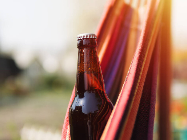 Botella de cerveza refrigerada cerrada sobre fondo de verano. Día soleado caliente - Foto, Imagen