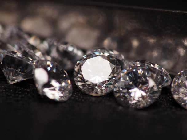 Close up shoot of group of sparkling diamonds, shoot on black leather as background - 写真・画像