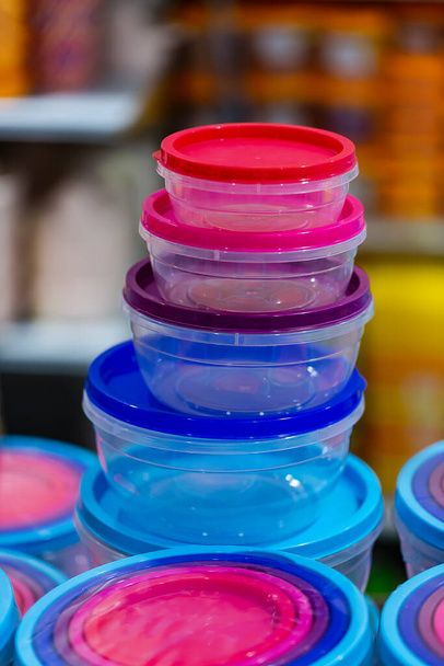 Leere farbige Plastikbehälter. Gruppe von Küchen-Lebensmittelbehältern aus Kunststoff im Geschäft. Aufbewahrungsboxen mit Deckel für Lebensmittel - Foto, Bild