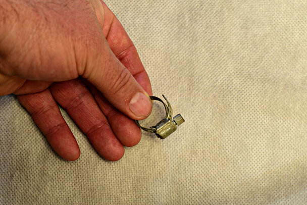 A man's hand holds a construction clamp used to connect pipes. High quality photo - Photo, Image