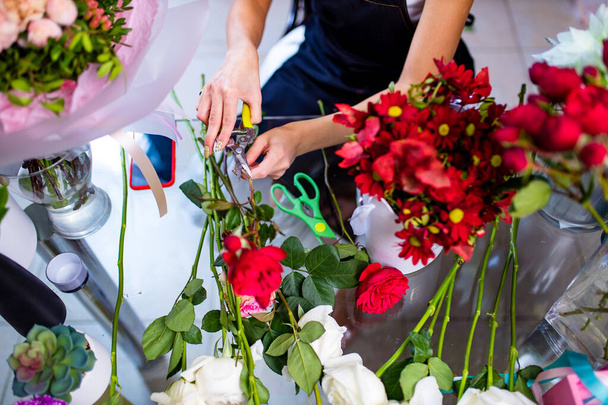Cropped view of florist making flower bouquet close up - Fotó, kép