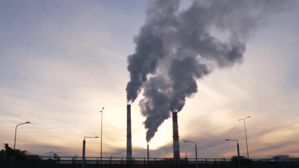 Slow motion shot of environment. Urban panorama with road traffic and factory chimneys. Sunny winter evening. Air pollution, global warming. - Footage, Video