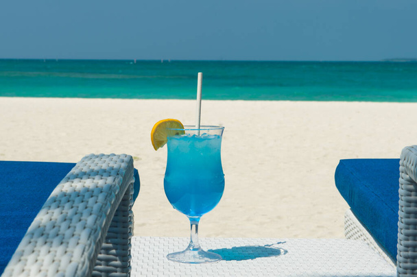 Cócteles tropicales azules sobre mesa de ratán blanco en el fondo del cálido océano turquesa. Vacaciones de verano exóticas. - Foto, Imagen