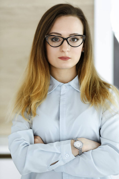 Business woman headshot at workplace in modern office. Unknown businesswoman standing straight with tablet computer. Young accountant or secretary looks good - Zdjęcie, obraz