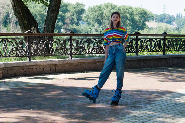 Attractive teenage girl on roller skates on a sunny summer day posing in the park - Foto, Imagem