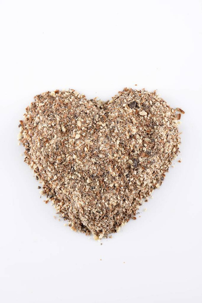 Blessed milk thistle seeds in the shape of heart on white background - Photo, Image