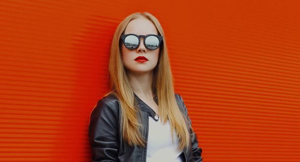 Portrait of young blonde woman in sunglasses on a red background - Foto, immagini
