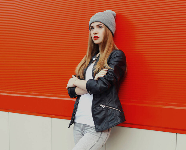 Stylish teenager girl posing in the city on a red wall background - Фото, изображение