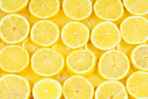 Una rebanada de jugosos limones amarillos frescos. Textura fondo, patrón. - Foto, Imagen