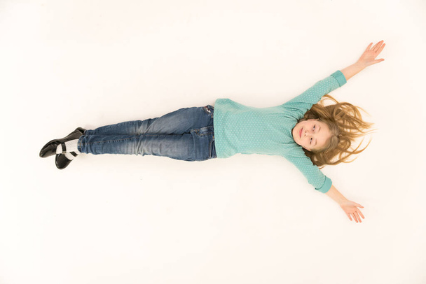 The cute girl lay on the floor. View from above - 写真・画像