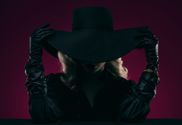 Elegant woman in black hat - Фото, зображення