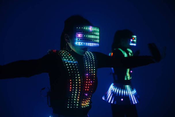 Two sexy disco dancers move in UV costumes. Parties and dances. - Zdjęcie, obraz