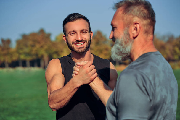 The two sportsmen greeting outdoor - Foto, imagen