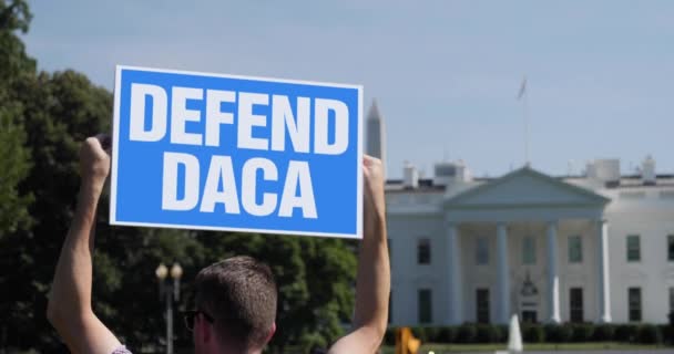 WASHINGTON DC - Alrededor de junio de 2020 - Un hombre sostiene un letrero de protesta DEFEND DACA fuera de la Casa Blanca. - Imágenes, Vídeo