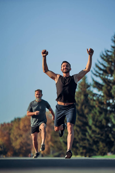 De twee atleten lopen marathon in het prachtige park - Foto, afbeelding