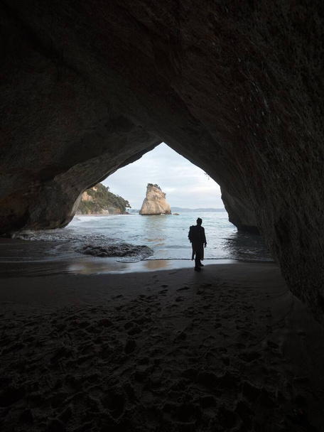 Silhouette de la personne sous l'arche Cathédrale Cove Te Hoho rocher Hahei Beach Péninsule de Coromandel Île du Nord Nouvelle-Zélande - Photo, image