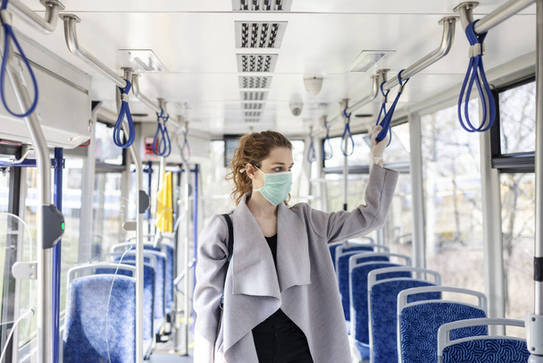 A young woman in the public transportation wearing face mask and gloves. - Fotografie, Obrázek
