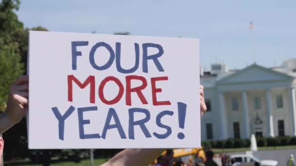 Mann hält vier weitere Jahre Schild vor Weißem Haus - Filmmaterial, Video
