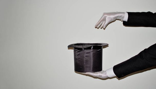 Portré fiatal fekete Illuzionista bűvész csinál mágia egy cilinder és egy varázspálca elszigetelt fehér háttér - Fotó, kép