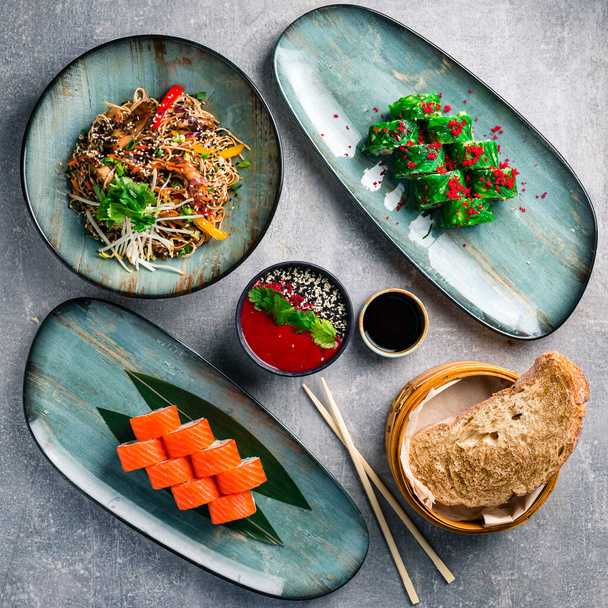 The concept of chineese cuisine. Assorted asian food set on grey table top view, flat lay - 写真・画像