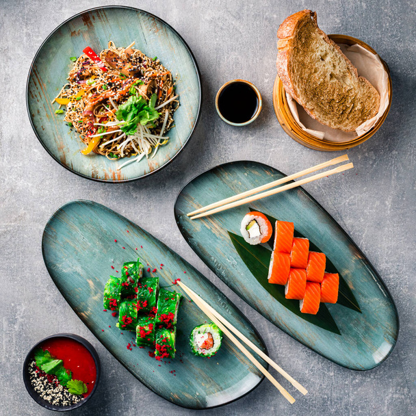 The concept of chineese cuisine. Assorted asian food set on grey table top view, flat lay - Fotó, kép