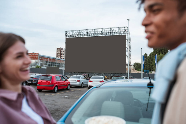 Young girl laughing with man near car during film session - Foto, Bild