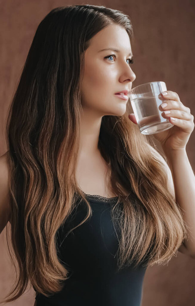 Mujer bebiendo agua de vidrio en casa, mantenerse saludable e hidratada, dieta y bienestar - Foto, Imagen