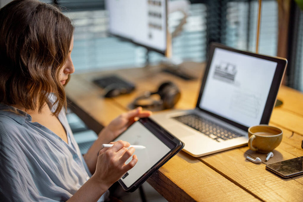 Mujer creativa con una tableta digital en la oficina en casa - Foto, imagen