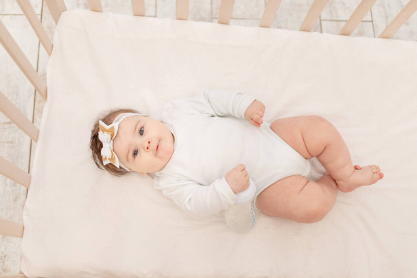 vauva kuusi kuukautta sängyssä pullon kanssa vettä valkoisessa kehossa - Valokuva, kuva