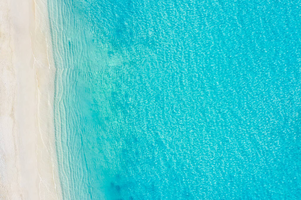 Paysage marin d'été belles vagues, eau de mer bleue dans une journée ensoleillée. Vue de dessus depuis un drone. Vue aérienne sur la mer, incroyable fond de nature tropicale. Belle mer lumineuse avec éclaboussures de vagues et concept de sable de plage - Photo, image