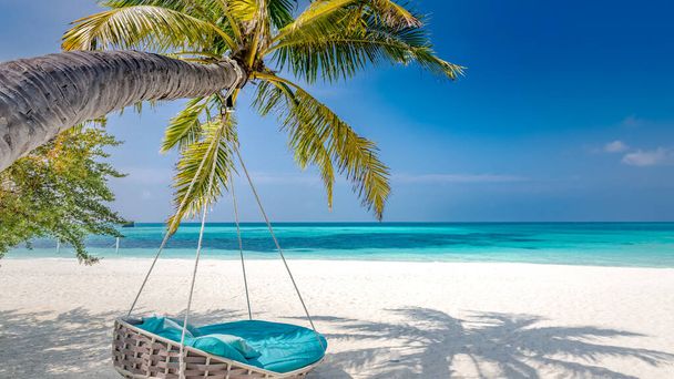 Пляжный фон в виде летнего пейзажа с пляжными качелями или гамаком и белым песком и спокойным морем для пляжного баннера. Перфектная концепция пляжного отдыха и летнего отдыха. Увеличение цветового процесса - Фото, изображение