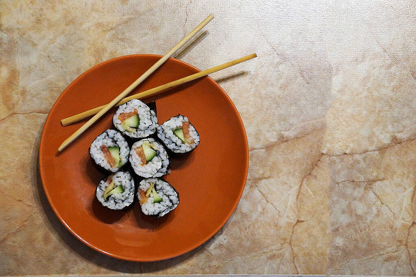 Sushi japonés y palos de madera en un plato, espacio para copiar - Foto, Imagen
