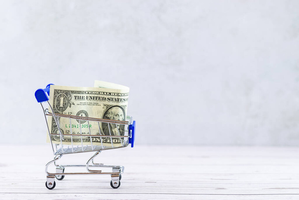 Financial concept, bank notes in the shopping cart. shopping cart with dollars banknotes. financial concept. Dollar in the basket - Photo, Image
