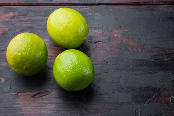 Whole green lime set, on old wooden table - 写真・画像