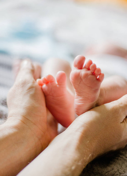 baby legs in mom's hands - Фото, изображение