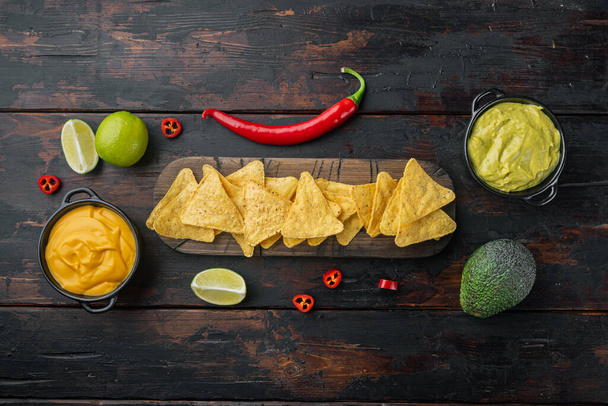 Corn tortilla chips nachos and dip sauce, on old wooden table, top view or flat lay - Foto, imagen