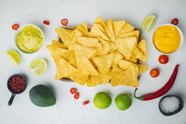 Domácí guacamole a sýrová omáčka s nacho, na bílém pozadí, horní pohled nebo ploché ležel - Fotografie, Obrázek