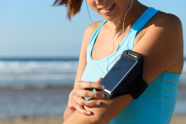 Sporty woman with phone sport band - Foto, Imagen