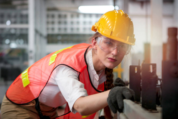 Teollinen insinööri työntekijä nainen yllään kypärä ja turvallinen lasit, työskentely väline tuotantolaitos tehdas, nuori kaunis nainen työskentelee teollisuudessa - Valokuva, kuva
