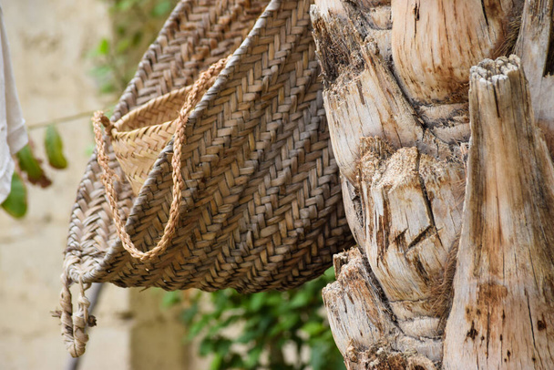 Χειροποίητο εργαλείο κουτί με ημερομηνίες φύλλο δέντρο, παλάμη ξηρό βάζο κρέμεται σε ξύλο στον κήπο, καφέ φόντο πολιτισμού πράγμα ταπετσαρία - Φωτογραφία, εικόνα