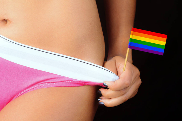 Сексуальна жінка тримає трусики для нижньої білизни та міні lgbt веселковий прапор. Закрити концепцію трансгендерного активізму
 - Фото, зображення