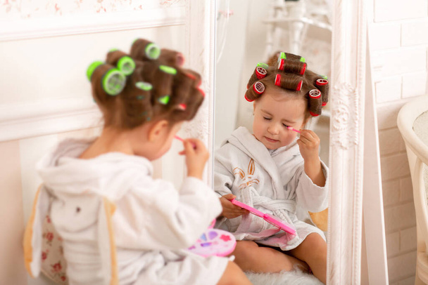 Adorable little girl learns to use baby cosmetics. Beauty day. - Фото, изображение