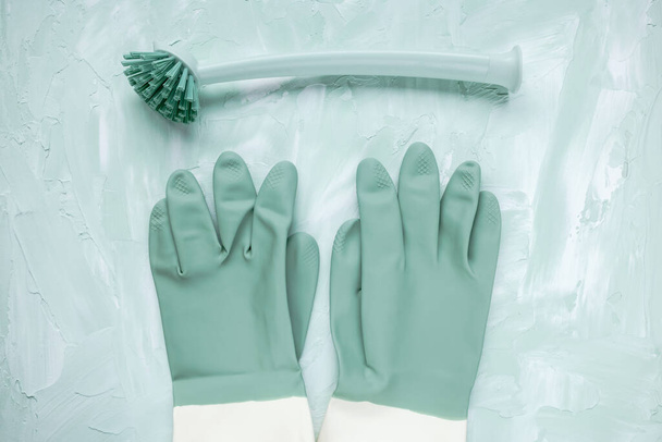 Lavavajillas cepillo y guantes sobre fondo verde - Foto, imagen