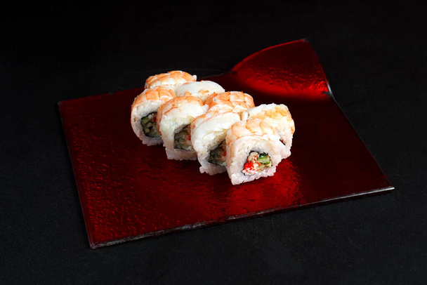 Aziatische keuken schotel, heerlijke sushi, sushi op een zwarte achtergrond, roll je net op een zwarte achtergrond - Foto, afbeelding