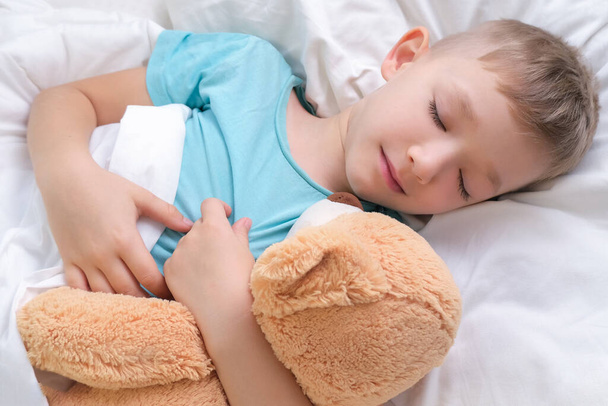 boy sleeping sweetly hugging a toy bear - Foto, immagini