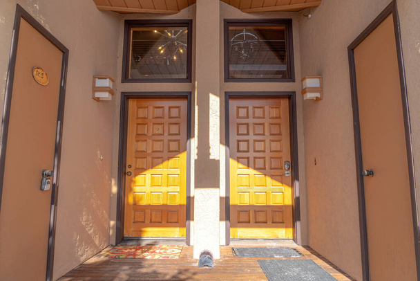 Змивні та панельні двері з трансомними вікнами на фасаді житлового будинку
 - Фото, зображення
