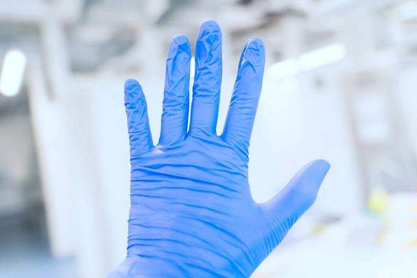 研究室の背景に青の保護窒化物手袋を手。COVID-19のコンセプト - 写真・画像