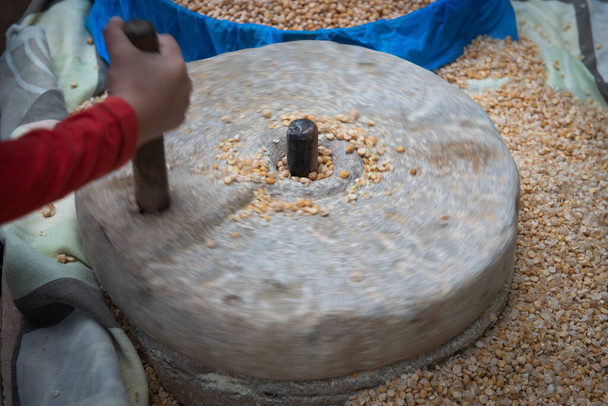 Human hand rotating stone grinding machine for smashing grains. Handmade manual equipment grind mill - Photo, Image