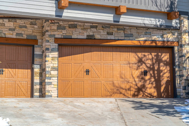 Park City Utah 'taki evin güneşli kahverengi garaj kapıları. Dış duvarları taştan. - Fotoğraf, Görsel